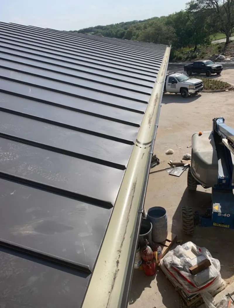 Standing seam panel and gutter detail on a metal roofing jobsite in Forest Lake